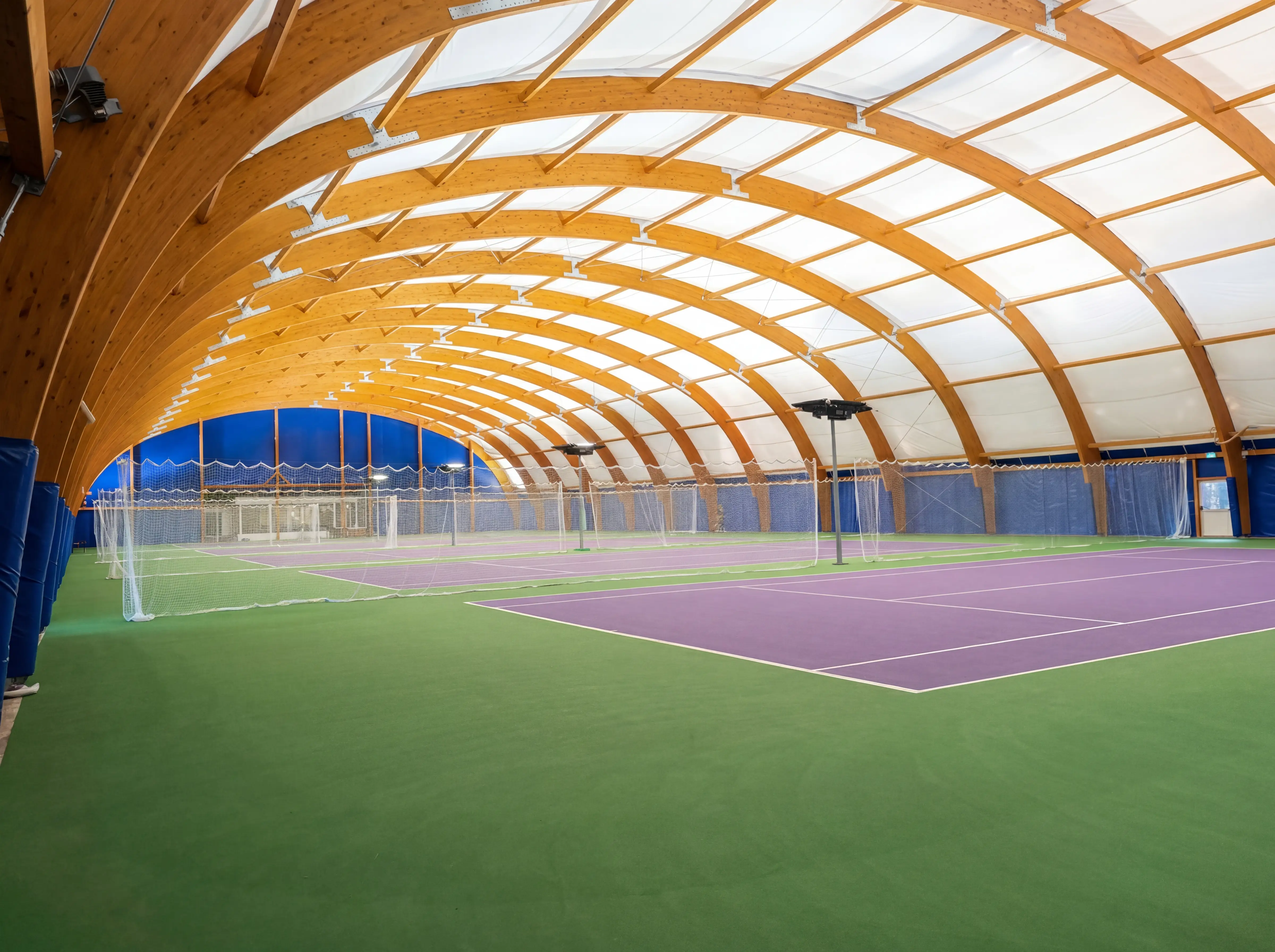 Interno di campi da tennis coperti da archi in legno lamellare con membrana traslucida
